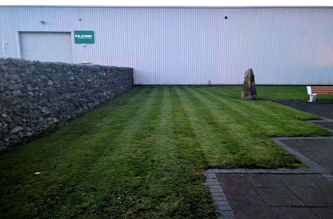 Striped lawn beside a gabion wall on an industrial estate unit